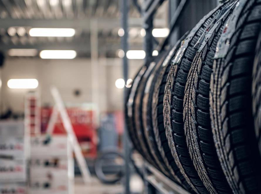 Close-up view of new car tires stacked on display inside an auto repair and tire shop.
